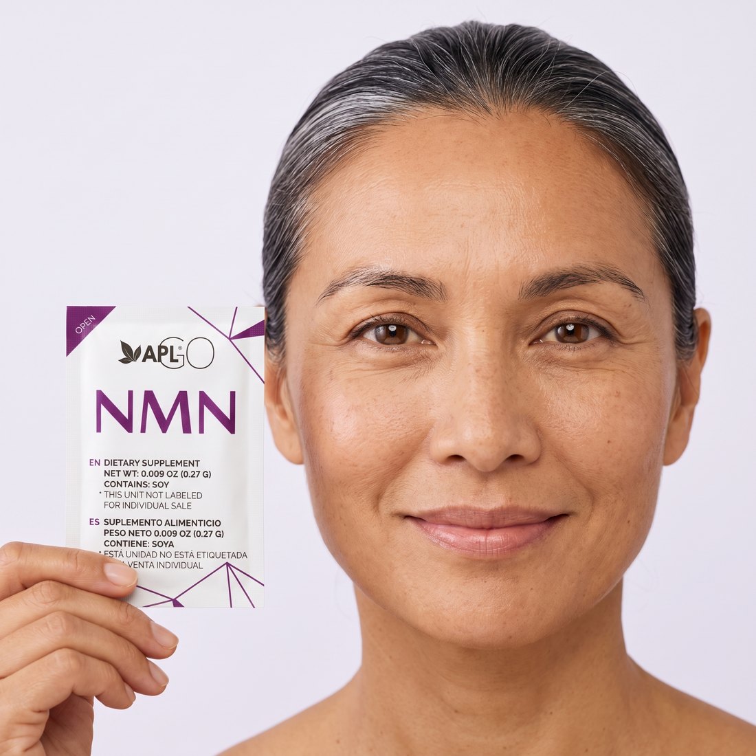 Mujer sosteniendo un sobre de NMN junto a la cara